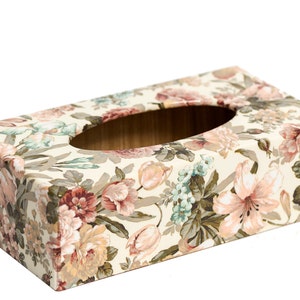Könnte beinhalten: Ein rechteckiger Taschentuchbox-Bezug mit einem Blumenmuster. Der Bezug ist aus Pappe und hat einen cremefarbenen Hintergrund mit rosa, roten und grünen Blumen.