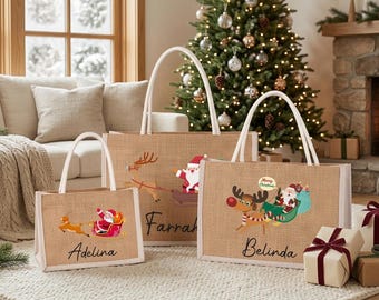 May include: Three rectangular jute tote bags with white handles, each featuring a printed graphic of Santa Claus in a sleigh pulled by a reindeer. The bags are personalized with the names Adelina, Farrah, and Belinda in black script lettering.