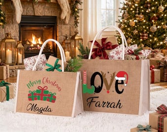 May include: Two rectangular tan burlap tote bags with white handles. The left bag features green and red gift boxes, the text Merry Christmas, and the name Magda. The right bag displays the word LOVE with a Santa hat and elf boot, and the name Farrah.