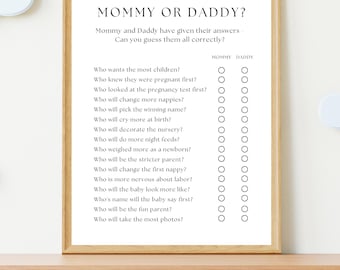 Puede incluir: Impresión enmarcada con el texto "MOMMY OR DADDY?" y una serie de preguntas con casillas de verificación. Las preguntas tratan sobre los roles de los padres. El marco es de color marrón claro.