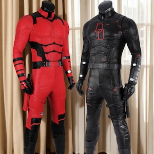 Może przedstawiać: Dwa pełne kostiumy superbohatera na manekinach. Jeden jest czerwony z czarnymi akcentami, drugi czarny z czerwonymi akcentami. Oba mają pasujące rękawice, buty i paski. Czerwony kostium ma stylizowaną "0" na pasku.