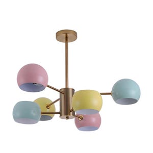 Op de afbeelding: Een moderne kroonluchter met een gouden afwerking en zes bolvormige tinten in pastelkleuren. De tinten zijn roze, geel en blauw en het armatuur hangt aan een centrale staaf.