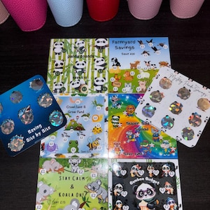 May include: A selection of themed savings cards, featuring pandas, farm animals, and koalas. Each card displays illustrations and text indicating savings amounts in pounds. These cards are designed for financial planning and budgeting.