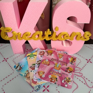 May include: A set of four square savings challenge cards featuring cartoon fast food illustrations and currency symbols. The cards are displayed in front of large, pink, 3D block letters spelling KS with the gold text Creations layered in front.