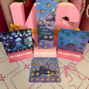 May include: A set of three printed savings challenge cards and one vertical bookmark featuring a sea witch character and shell icons. The cards include text such as The Enchanted Shell Challenge, Potion Perfect Savings, and Sea Witch Savings, with KS-CREATIONS branding on pink stands.