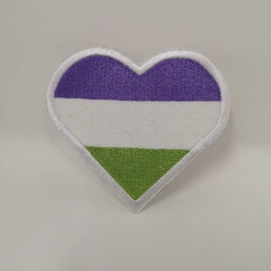May include: Heart-shaped patch with a white border, featuring horizontal stripes of purple, white, and green. The patch is embroidered with a textured appearance, suitable for sewing or ironing onto fabric. Ideal for expressing identity.