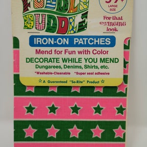 May include: Vintage iron-on patches on a cardboard backing. The patches feature a pink and green star pattern. The packaging includes text that reads "Fuddle Duddle" and "Iron-On Patches". The price is 59¢ for two patches.
