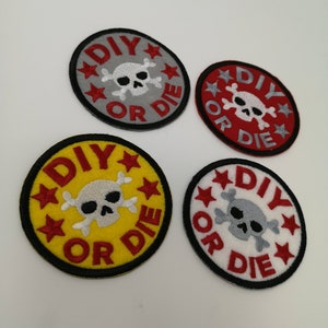 Può includere: Quattro toppe circolari con la scritta "DIY OR DIE" e un teschio con ossa incrociate. Le toppe sono grigie, rosse, gialle e bianche, ognuna con una diversa combinazione di colori. Stelle rosse circondano il testo.