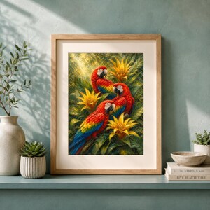 Puede incluir: Una lámina de arte enmarcada que muestra tres guacamayos rojos vibrantes posados entre un exuberante follaje tropical verde y flores de bromelia de color amarillo brillante. Los loros lucen un plumaje rojo, amarillo y azul intenso.