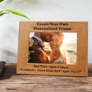 May include: A wooden photo frame displaying a wedding photograph. The frame is inscribed with "Create Your Own Personalised Frame" and "Any Text - upto 3 lines 6 colours - sizes from 15x10cm upto 40x30cm".