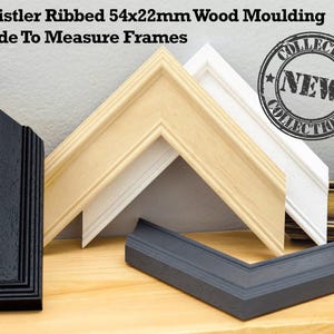 May include: A selection of wooden picture frame mouldings in black, white, natural, and grey. The text reads "Whistler Ribbed 54x22mm Wood Moulding Made To Measure Frames". The dimensions are 5.4cm x 2.2cm. A "NEW COLLECTION" stamp is visible.