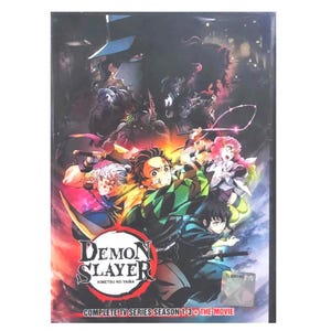 Puede incluir: Caja de DVD de la serie de anime "Demon Slayer: Kimetsu no Yaiba". La portada presenta una ilustración dinámica de personajes en acción, con el título en rojo y blanco. El set incluye la serie de TV completa de las temporadas 1-3 y la película.