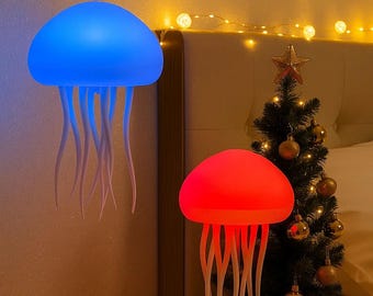May include: Two jellyfish-shaped lamps, one blue and one red, with white tendrils. The blue lamp hangs from the ceiling, while the red lamp sits on a table. A small Christmas tree with gold ornaments is in the background.