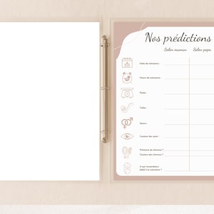 May include: A clear binder with a baby shower prediction game sheet. The sheet has a pink border and features the text "Nos pr&eacute;dictions" and prompts for birth date, time, weight, and other details. The binder is open.