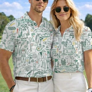 以下が含まれることがあります： 緑色のゴルフをテーマにした落書きプリントが施された、お揃いの白いゴルフシャツを着た2人。 シャツは襟付きで半袖です。 左の人はカーキ色のズボンを履いており、右の人は白いショートパンツを履いています。 サングラスが着用されています。