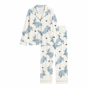 Op de afbeelding: Een tweedelige pyjamaset met een witte achtergrond en een herhaald patroon van lichtblauwe konijnen en donkerblauwe sterren. De set bevat een overhemd met knopen, reverskraag en lange mouwen en een bijpassende broek.
