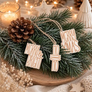 Drei Geschenkanhänger Weihnachten auf Tannenzweigen mit Zapfen und warmem Kerzenlicht für eine natürliche und festliche Geschenkverpackung Weihnachten.