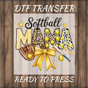 May include: DTF Transfer design with the words "Softball MAMA" in black, yellow, and leopard print. Includes a softball, glove, bat, and bow. The words "READY TO PRESS" are at the bottom. The background is a wood grain pattern.