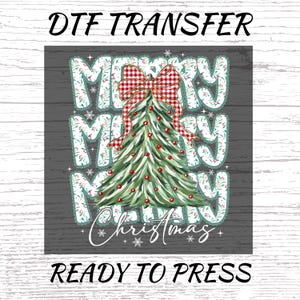May include: DTF transfer design with the text "MERRY MERRY MERRY" in a floral font, a Christmas tree, and a red and white plaid bow. The words "Christmas" and "READY TO PRESS" are also included in the design.