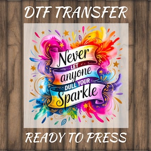 May include: DTF transfer with a colorful design featuring the text "Never let anyone dull your sparkle." The design includes vibrant splashes of pink, yellow, blue, and orange, with star accents. The words "Ready to press" are also included.