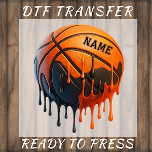 May include: DTF transfer of a basketball with a black and orange dripping design. The word "NAME" is printed on the basketball. The text "DTF TRANSFER" and "READY TO PRESS" are printed above and below the basketball.