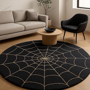Könnte beinhalten: Ein runder, schwarzer Teppich mit einem goldenen Spinnennetz-Design. Der Teppich liegt auf einem Holzboden, mit einem Sofa, einem Stuhl und einem Couchtisch im Hintergrund. Ein dekoratives Element für ein Wohnzimmer.