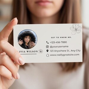 Op de afbeelding: Een visitekaartje met de tekst "GET TO KNOW ME." bevat een foto, contactgegevens en social media handles. De kaart heeft een bloemmotief en de naam "LIVIA WILSON."