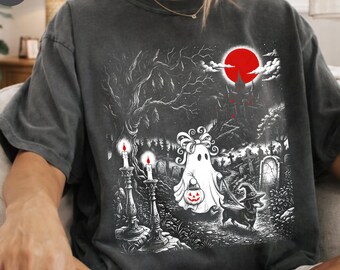 Może przedstawiać: Ciemnoszary t-shirt z nadrukiem graficznym przedstawiającym ducha z kokardą trzymającego wiaderko w kształcie dyni oraz jamnika w kapeluszu czarownicy. Scena zawiera cmentarz, zamek i duży czerwony księżyc na niebie.