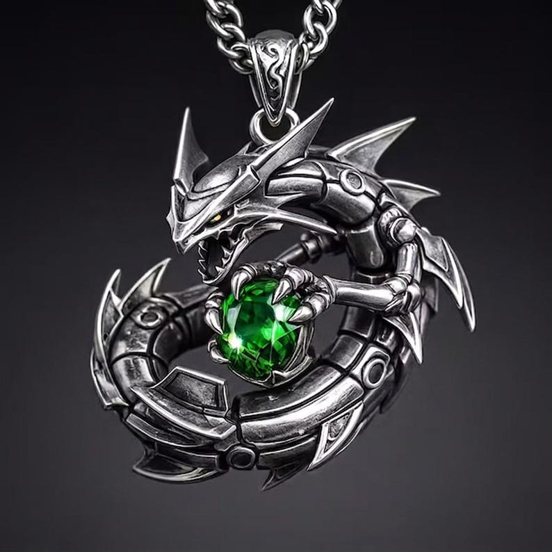 May include: A silver-toned dragon pendant necklace. The dragon is intricately detailed, holding a large, round, green gemstone. The pendant hangs from a matching chain. The dragon's design features sharp edges and a menacing expression, creating a bold statement piece.