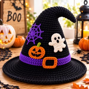 May include: A black crocheted witch hat featuring a purple band with an orange buckle, a purple spiderweb appliqué, a small orange jack-o'-lantern, and a white ghost figure attached to the front of the pointed crown and wide brim.