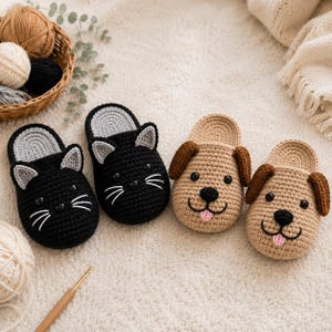 Op de afbeelding: Twee paar handgemaakte gehaakte pantoffels. Eén paar heeft zwarte kattengezichten met grijze binnenoren en witte snorharen. Het andere paar heeft beige hondengezichten met bruine flaporen, roze tongen en zwarte kraaloogjes en neuzen.