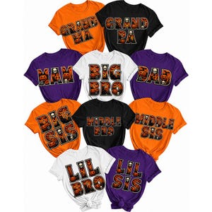 May include: A collection of ten short-sleeved t-shirts in orange, black, white, and purple. Each shirt features a Halloween-themed graphic with text including GRANDMA, GRANDPA, MOM, DAD, BIG BRO, BIG SIS, MIDDLE BRO, MIDDLE SIS, LIL BRO, and LIL SIS.
