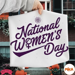 May include: White rectangular sign with the text "National Women's Day" in purple script, featuring a flower and the female symbol. The sign is held up by a person's hand.