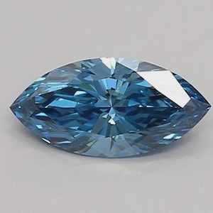May include: A marquise-cut gemstone with a vibrant blue colour and a faceted surface. The stone features a pointed shape at both ends and displays multiple internal reflections and light refractions across its polished, symmetrical surface.
