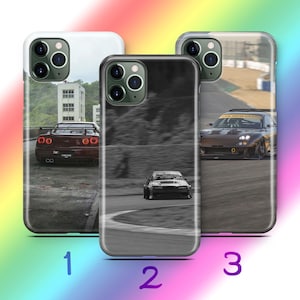 Op de afbeelding: Drie smartphonehoesjes met afbeeldingen van autoraces. Hoesje 1 toont een donkerrode sportwagen vanaf de achterkant. Hoesje 2 is een zwart-witafbeelding van een auto op een circuit. Hoesje 3 toont een bruine sportwagen op een circuit met een gele banner.