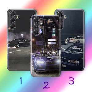 Può includere: Tre cover per smartphone con design automobilistici. La cover 1 mostra un'auto nera che derapa di notte. La cover 2 mostra un'auto sportiva blu in una strada con insegne al neon. La cover 3 mostra un'auto scura con testo giapponese sul parabrezza.