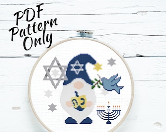 May include: A cross-stitch pattern in a wooden embroidery hoop. The design features a gnome wearing a blue hat with a Star of David, holding a menorah and a dove with an olive branch. The text "PDF Pattern Only" is at the top.