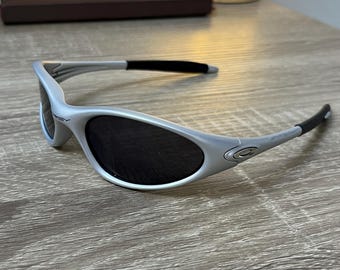 Oakley Minute 1.0 – Sleek Silver Wraparound Sunglasses With Black