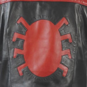 May include: Black and red leather jacket with a large red spider emblem on the back. The jacket features a red upper back and collar, with black leather on the lower back and sleeves. A stylish outerwear piece.