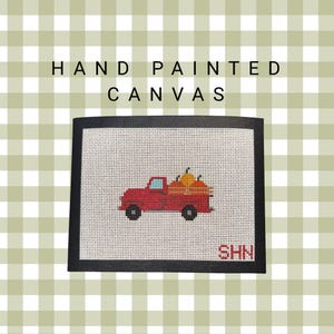 May include: Hand-painted canvas featuring a red truck carrying pumpkins. The artwork has a black border and the text "HAND PAINTED CANVAS" is at the top. The initials "SHN" are in the bottom right corner. The background is a green and white checkered pattern.