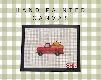 May include: Hand-painted canvas featuring a red truck carrying pumpkins. The artwork has a black border and the text "HAND PAINTED CANVAS" is at the top. The initials "SHN" are in the bottom right corner. The background is a green and white checkered pattern.
