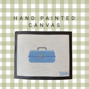 May include: Hand-painted canvas featuring a blue toolbox design with a black border. The canvas has a white background with a grid pattern and the text "HAND PAINTED CANVAS" at the top. The initials "SHN" are in the bottom right corner.