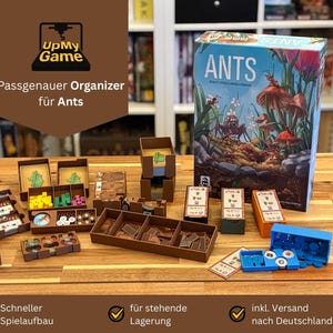 May include: A board game organiser for the game "Ants" with various brown wooden storage containers and a game box. The box art features illustrations of ants and mushrooms. The organiser is designed to keep game components organised.