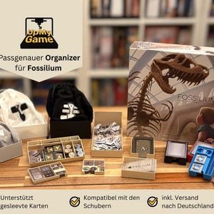 May include: A tabletop game organizer for Fossilium, featuring various storage boxes, bags, and game components. The Fossilium game box is visible, showcasing a dinosaur skeleton illustration. The organizer includes the text "UpMy Game" and "Passgenauer Organizer für Fossilium".