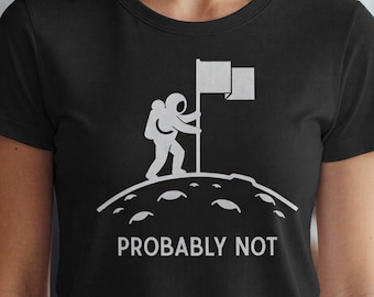 May include: Black t-shirt with a white graphic of an astronaut planting a flag on a planet's surface. The text "PROBABLY NOT" is printed below the graphic in white.