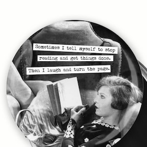 May include: A black and white round magnet featuring a vintage image of a woman reading. Text on the magnet reads: "Sometimes I tell myself to stop reading and get things done. Then I laugh and turn the page."