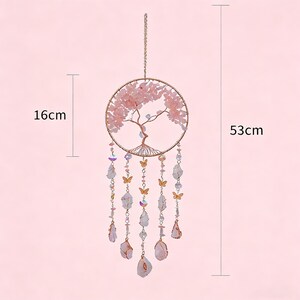 Puede incluir: Adorno colgante decorativo con dise&ntilde;o de &aacute;rbol, cristales rosas y mariposas. El marco circular mide 16 cm de ancho y la longitud total es de 53 cm. Tiene una cadena dorada para colgar.
