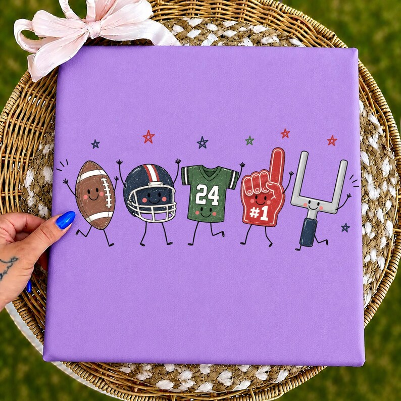 May include: A square purple canvas featuring a cartoon illustration of five American football-themed characters with smiling faces, including a brown football, a black helmet, a green jersey with the number 24, a red foam finger, and a goalpost.