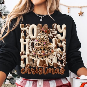 Könnte beinhalten: Schwarzes Sweatshirt mit dem Schriftzug "Howdy Howdy Howdy Christmas" in brauner, strukturierter Schrift. Das Design zeigt einen Weihnachtsbaum mit Cowboyhut, verziert mit bunten Ornamenten.