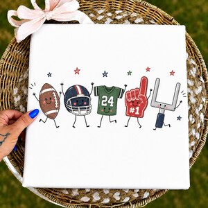 May include: A white square canvas featuring a cartoon illustration of five American football-themed characters with smiling faces, including a brown football, a helmet, a green jersey with the number 24, a red foam finger, and a goal post.
